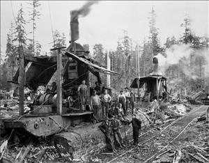  A group of men in work clothes stand on and around large machinery in the forest. The machines have steam coming out the top. 